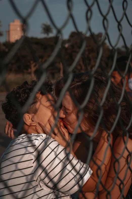 some very pretty people close together behind a fence