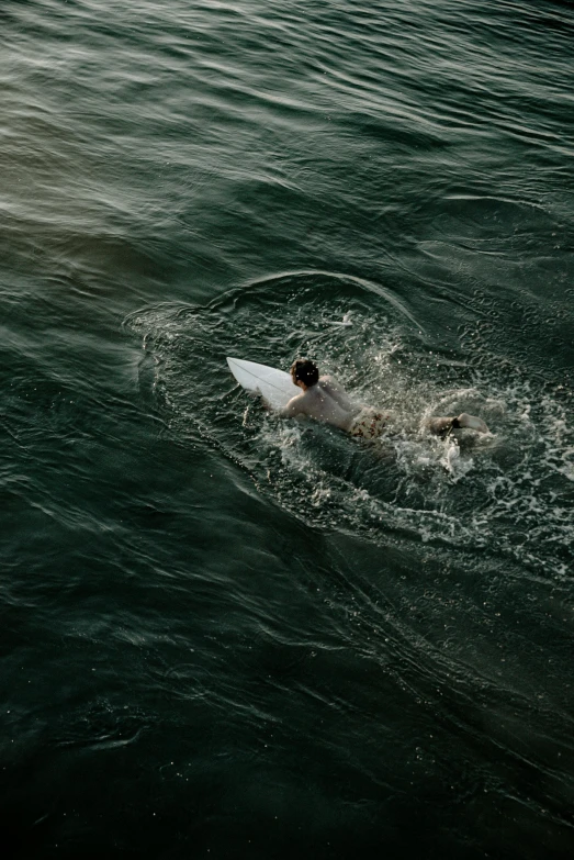 a man riding on top of a surfboard in the ocean