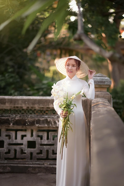 woman dressed in white holding a large bouquet