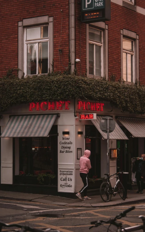 a woman walks by a building that reads paradise diner