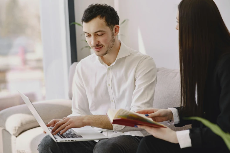 two people are sitting in a room with a laptop