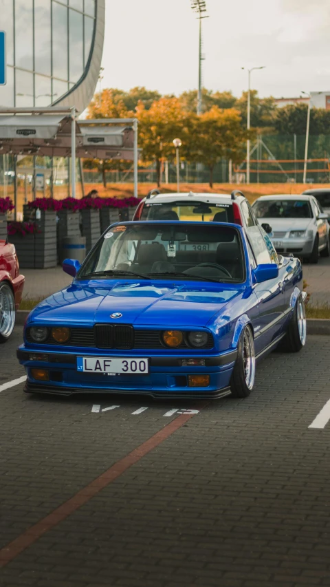 there is a blue car and other cars that are parked