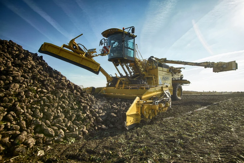 an old, yellow construction equipment is sitting on a pile of gravel