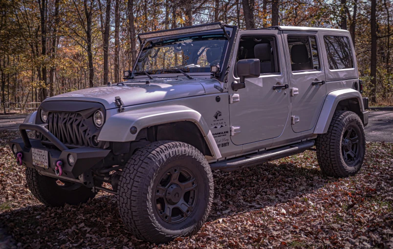 a jeep parked by the side of a wooded road