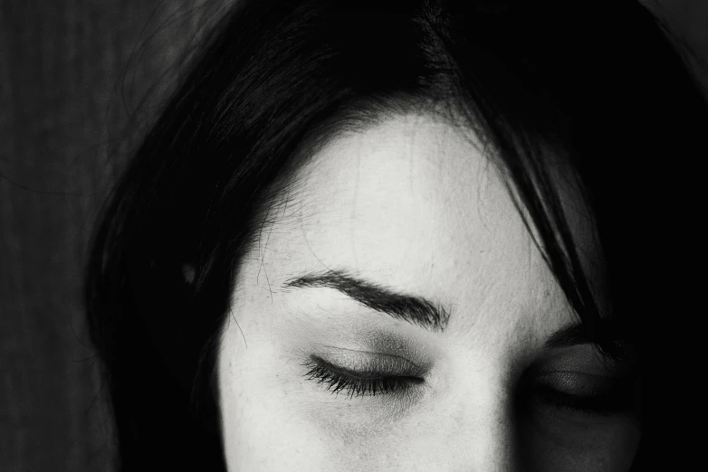 a girl with eyeliners and a hairdo holding her hands close to her face