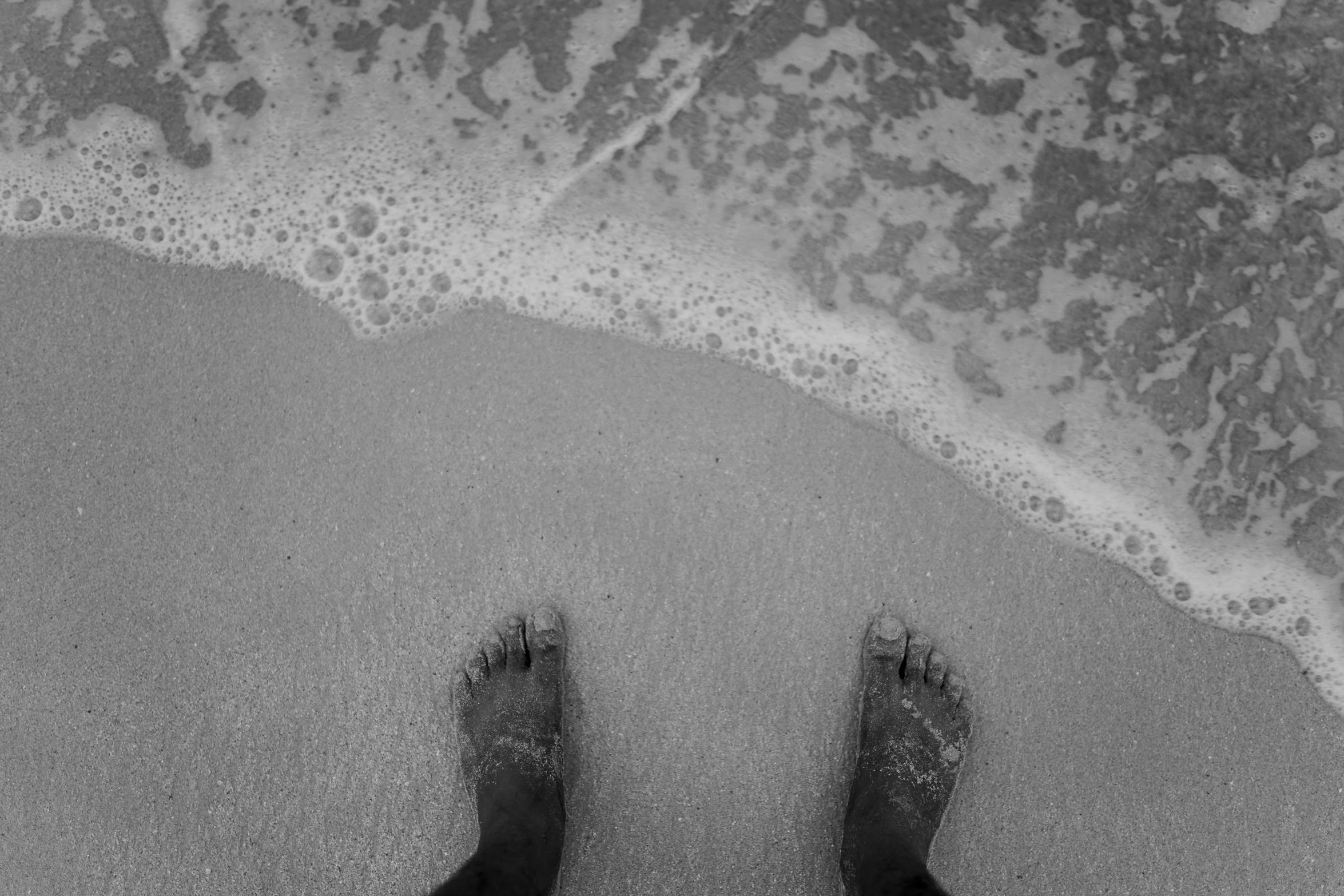 feet and toes in the sand of the ocean