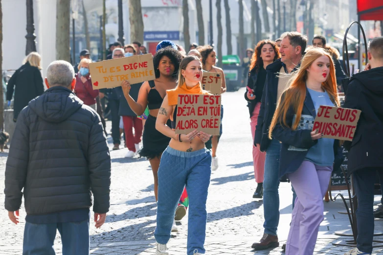 people walking down the street holding placas