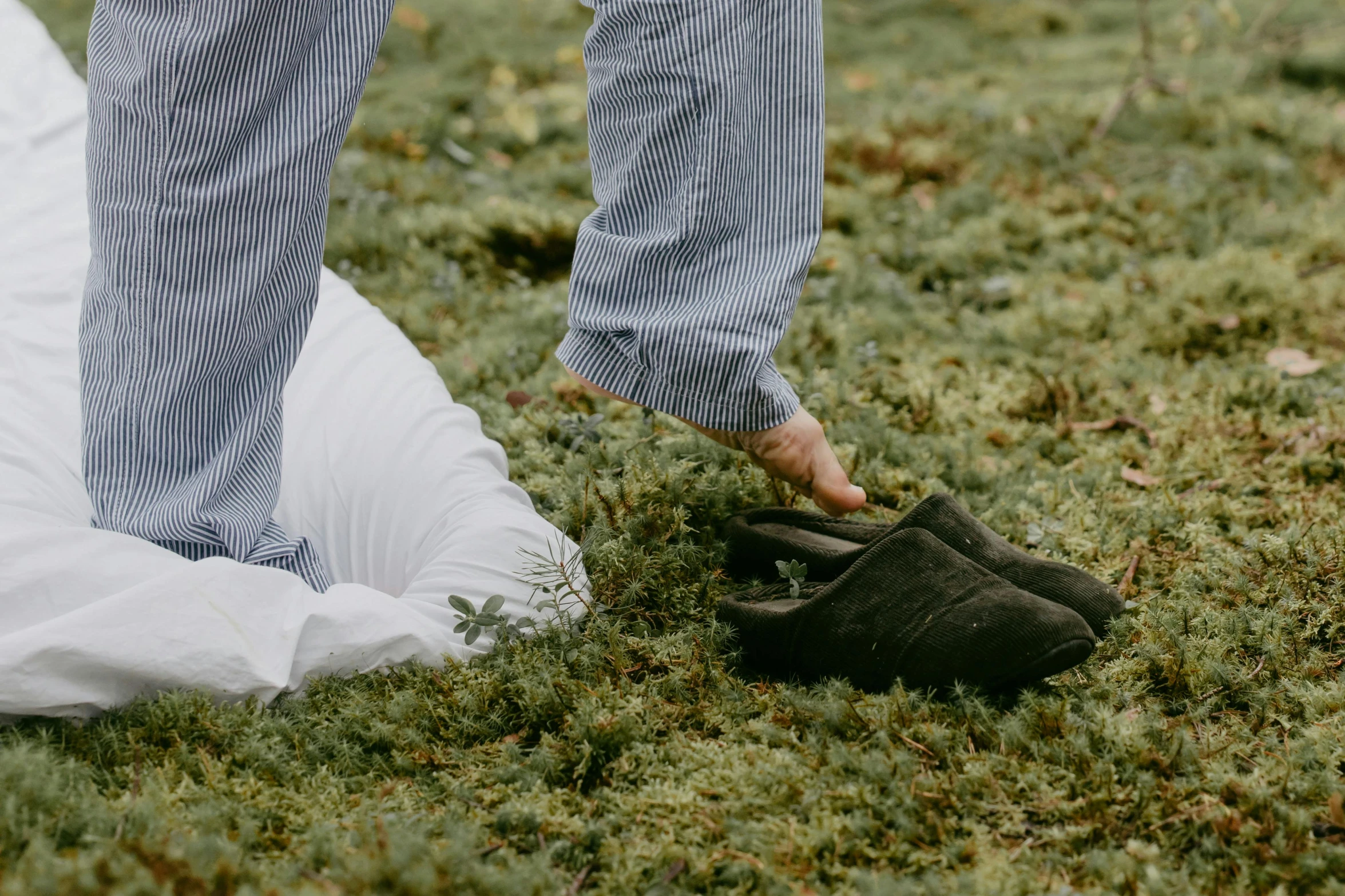 someone wearing slippers in a field of green grass