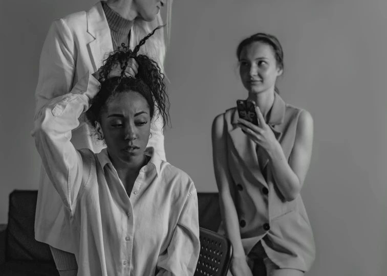 a person sitting on the bed and another woman standing near her