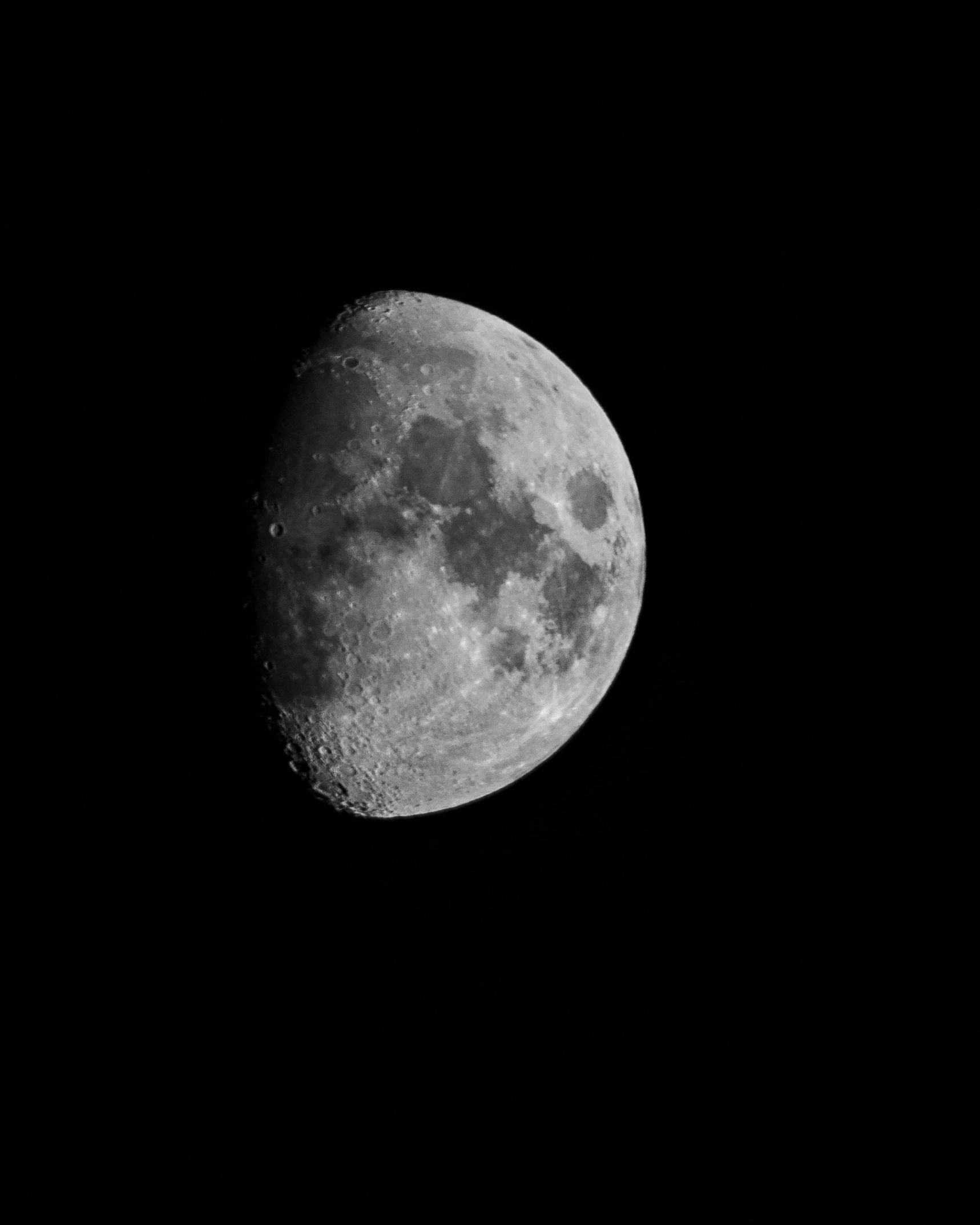 a very bright moon with clouds and black skies