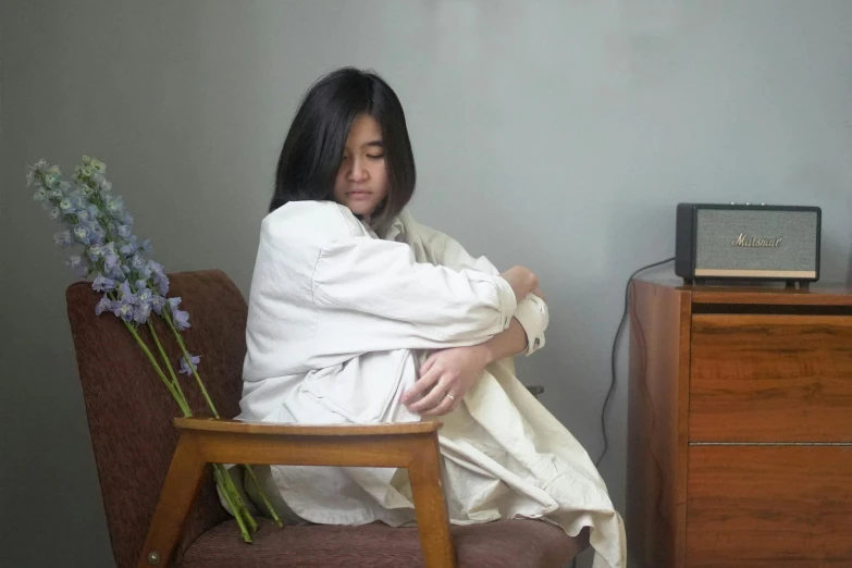 a person sitting on a chair by flowers