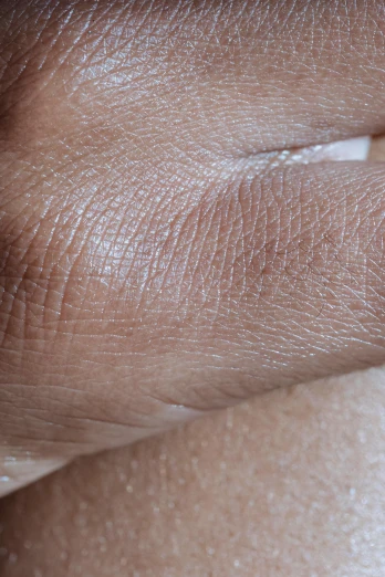 a closeup po of the side of someone's hand holding a light colored liquid