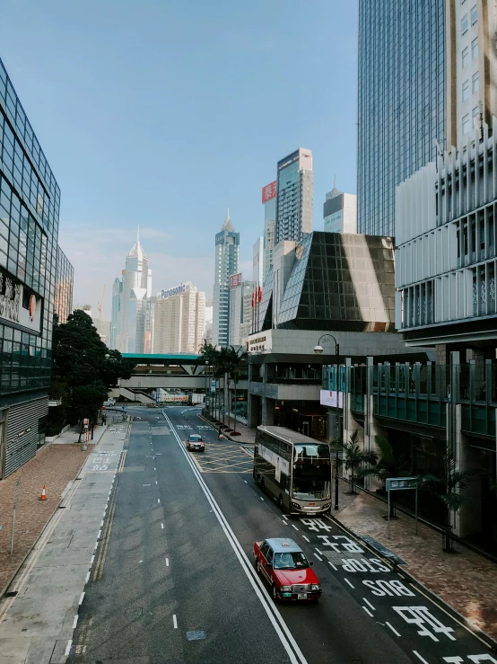 an empty city street with tall buildings and empty cars