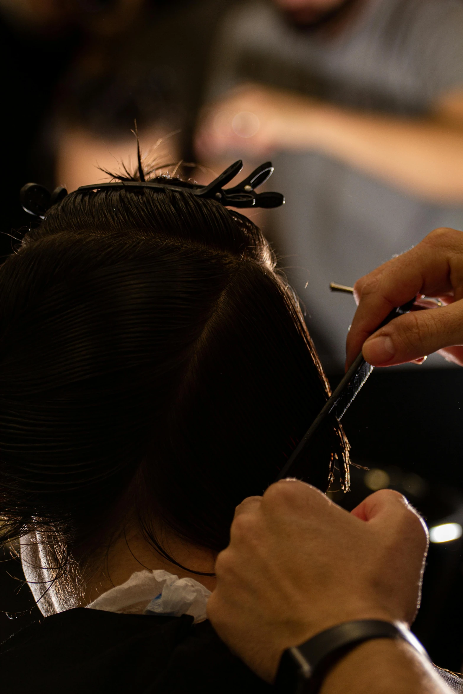 a person is having their hair cut