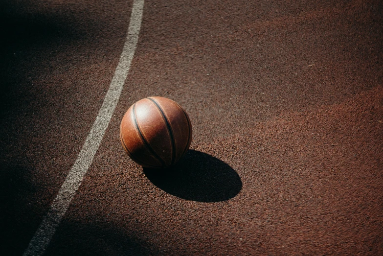 a basketball sitting on the side of a court