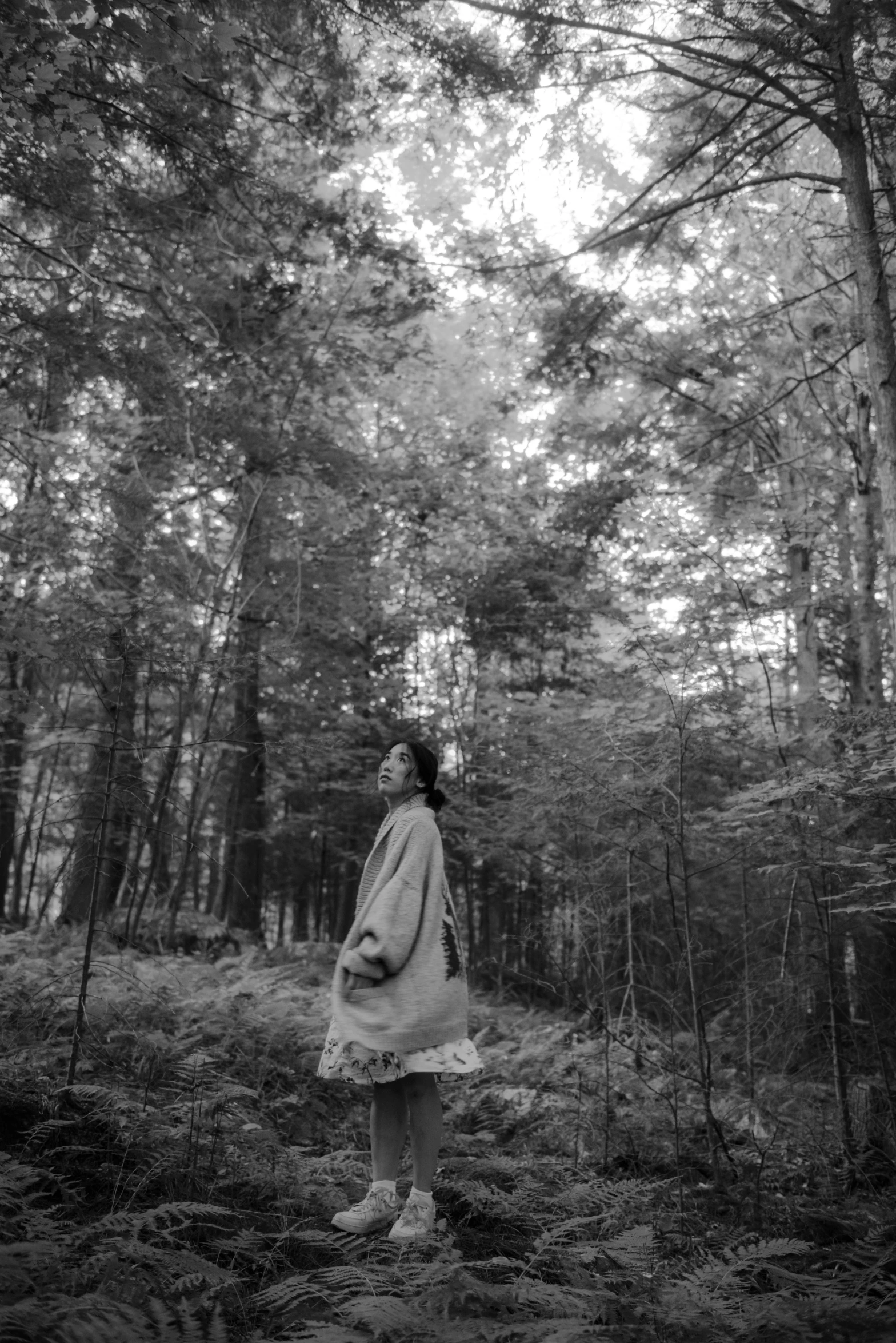 a black and white image of a woman in the woods