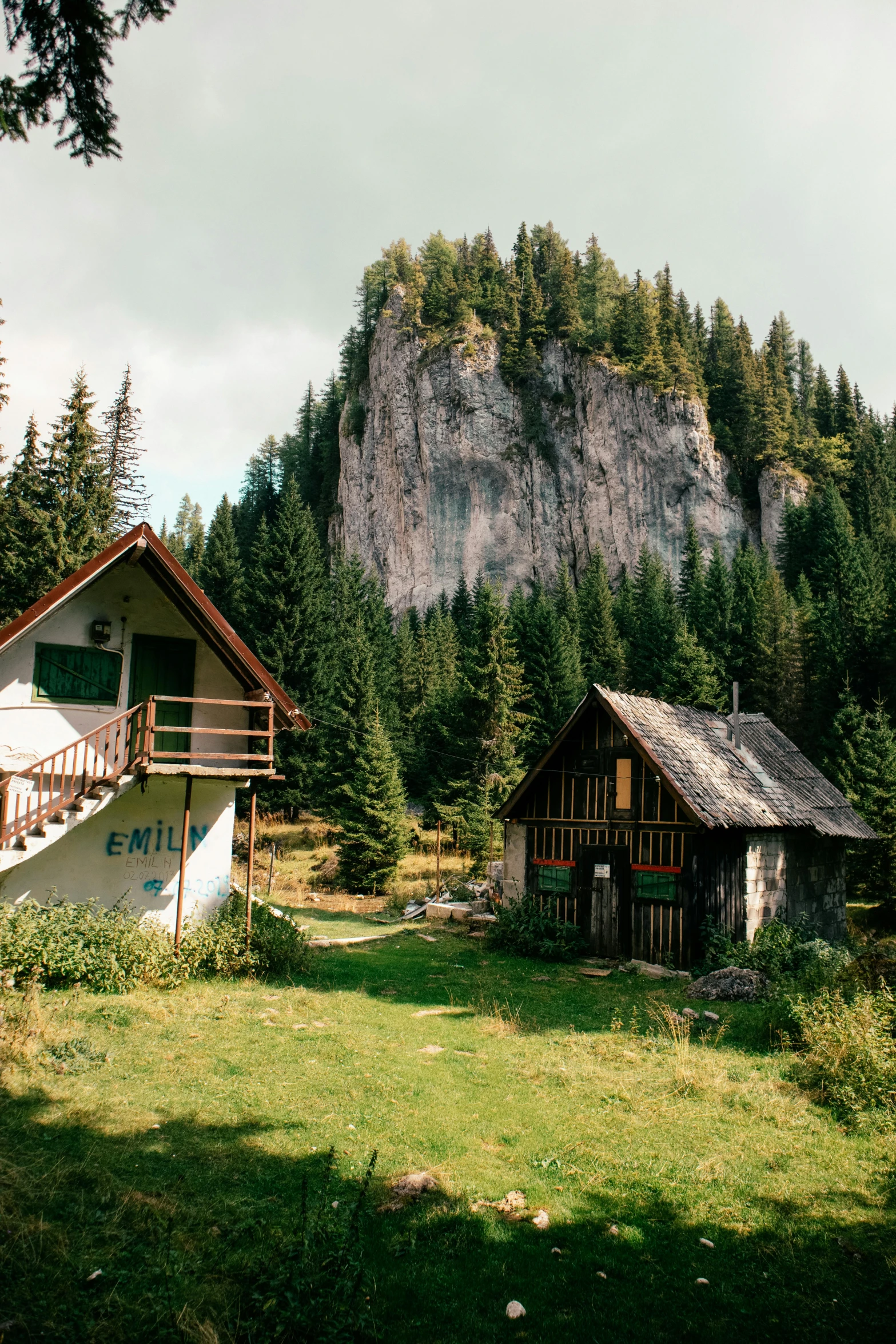 small, old cabin - type house nestled on a hill top