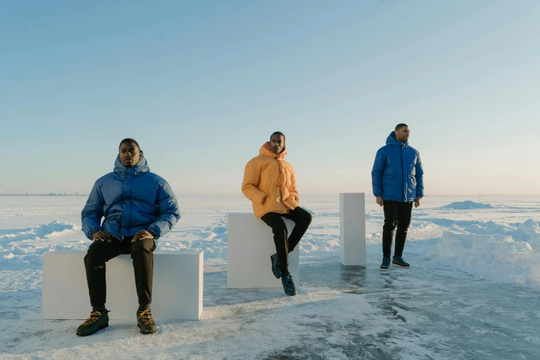 a group of people sitting on white blocks in the snow