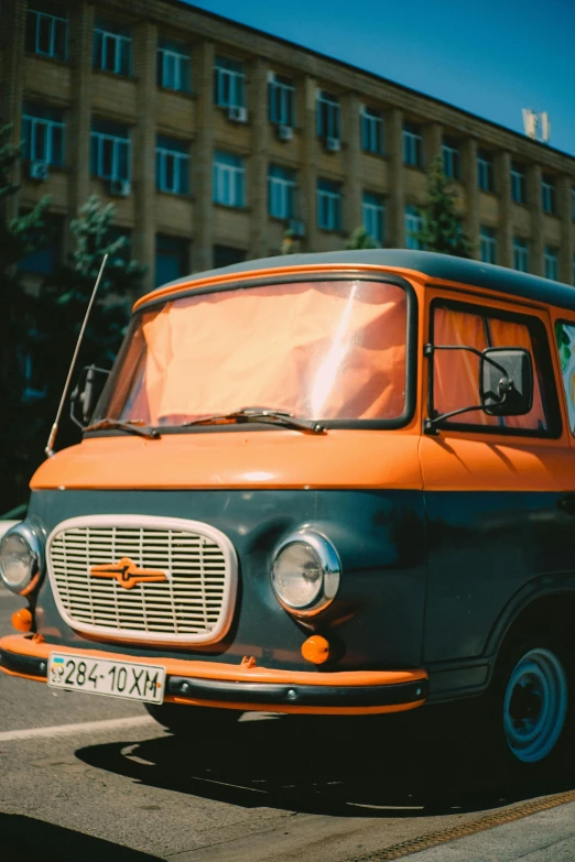 an orange and black van parked on a street