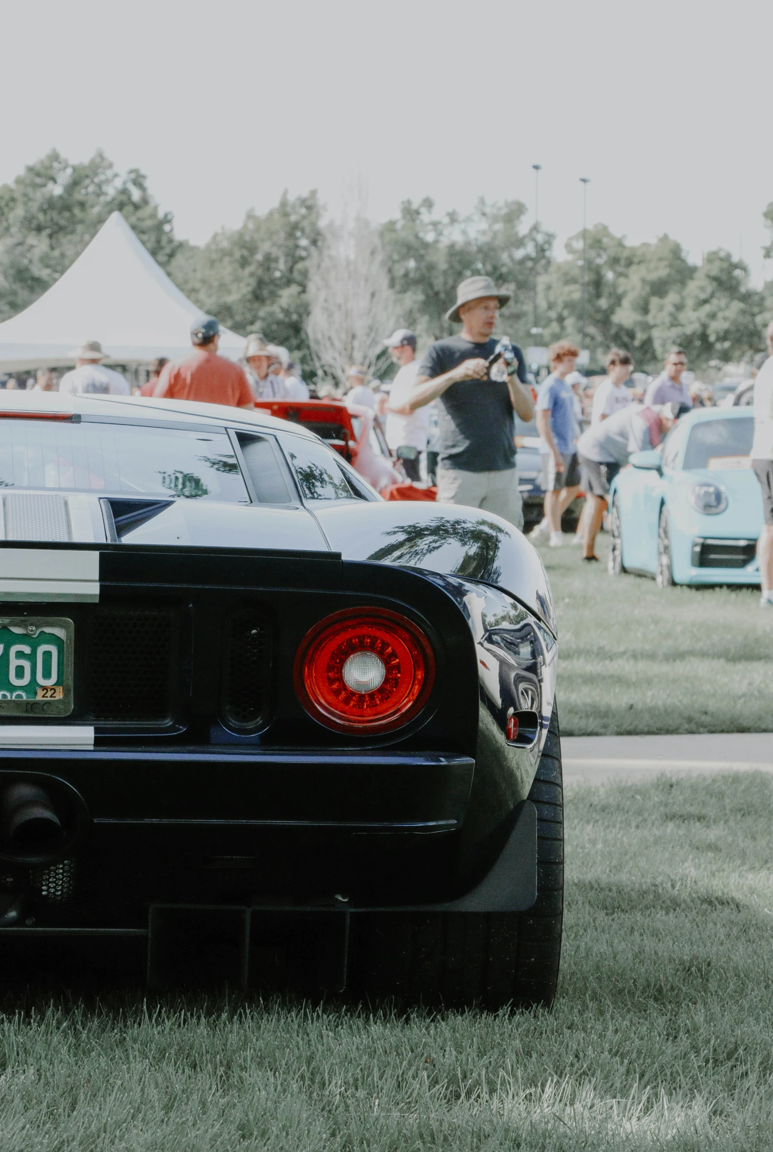 a car with red tail lights parked in the grass