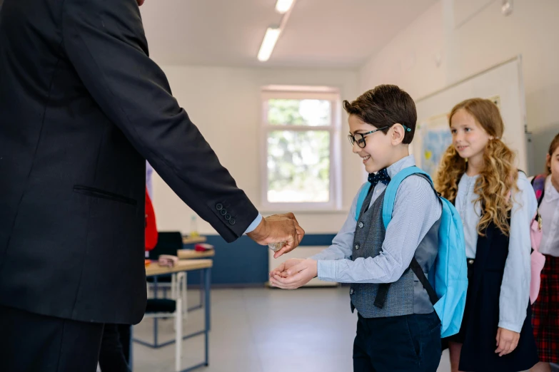 young child greeting a smiling man in a dress clothes