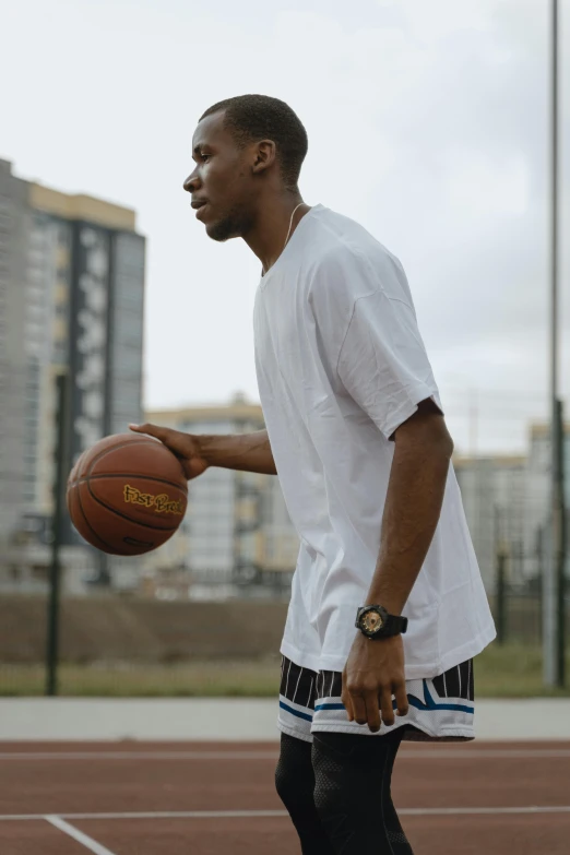 a black man holding a basketball ball on top of a basketball court