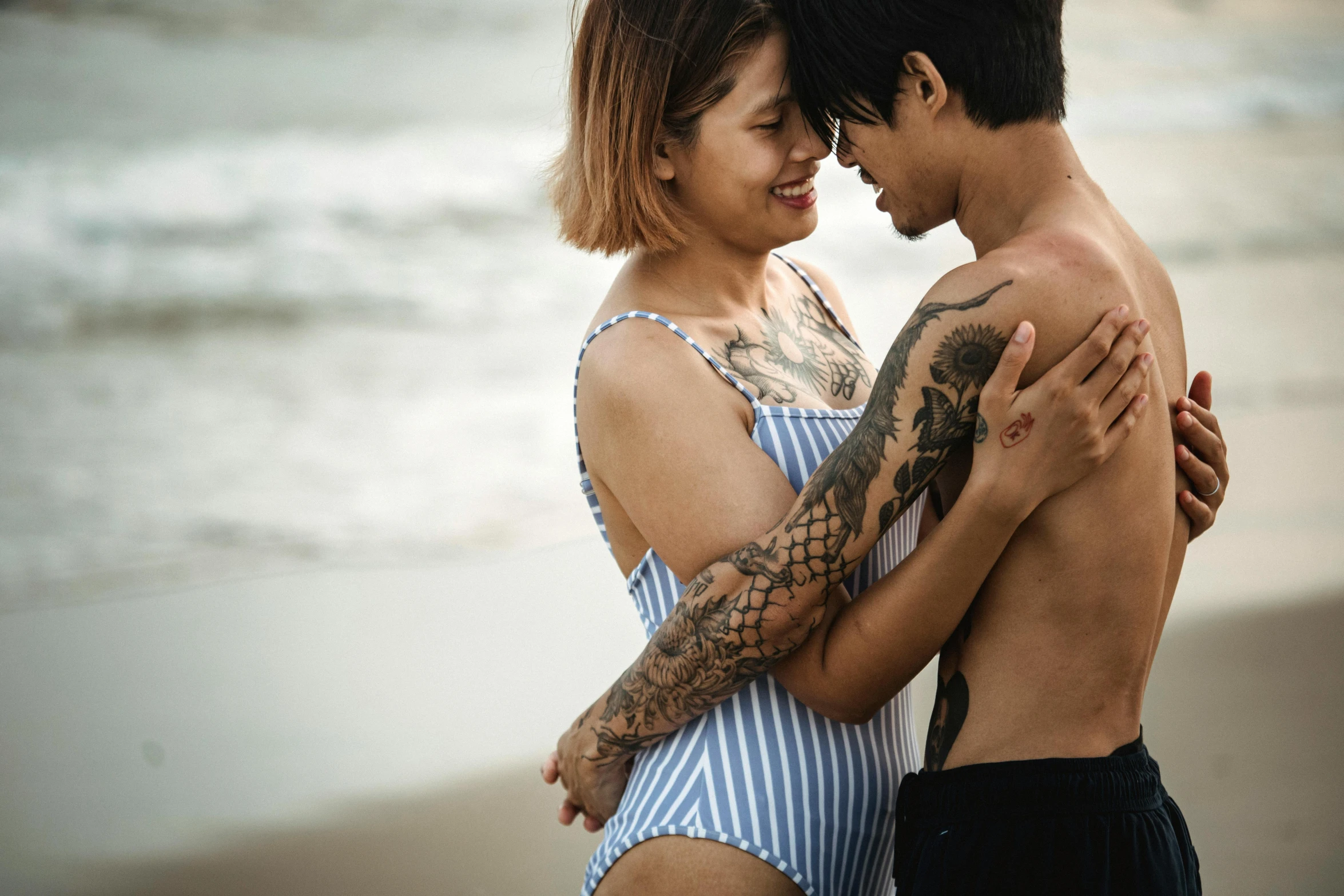 a man and woman in bathing suits emcing at the beach