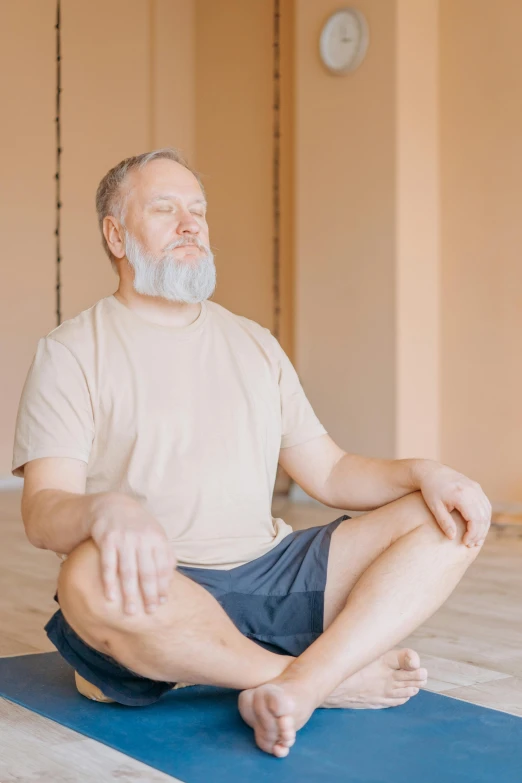 an older man is sitting in a lotus position