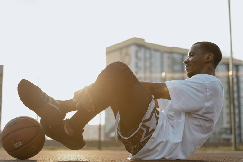 a man is sitting down on a basketball court