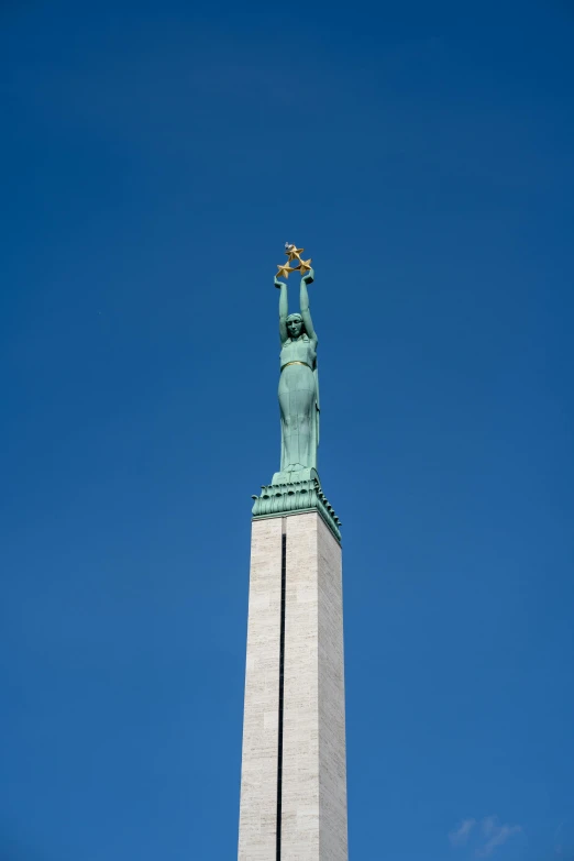 an old statue stands on a rock in front of the sky