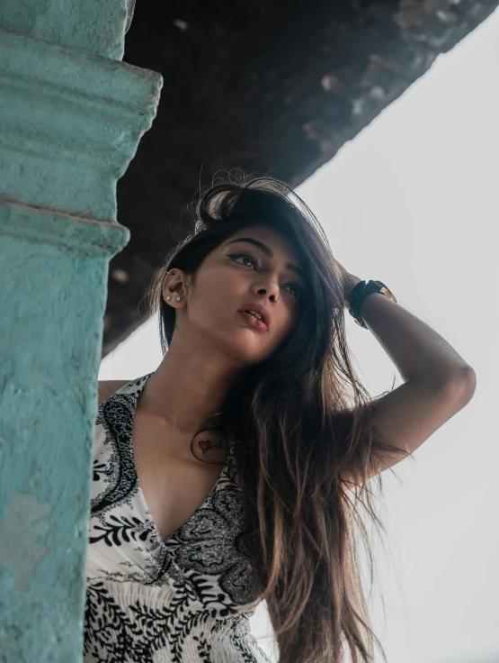 a woman standing in an alley holding her hair up