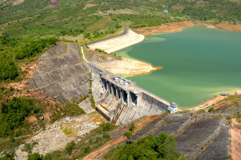 a large lake sitting near the side of a dirt hillside