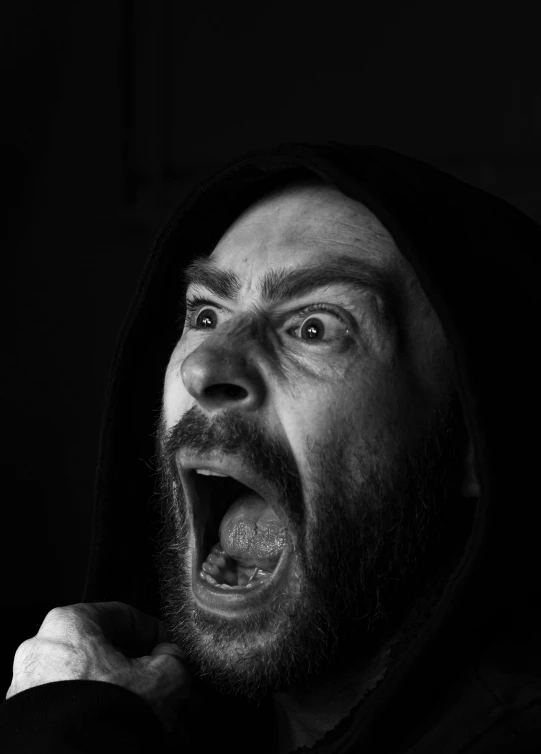 man with hood open making surprised face in dark room