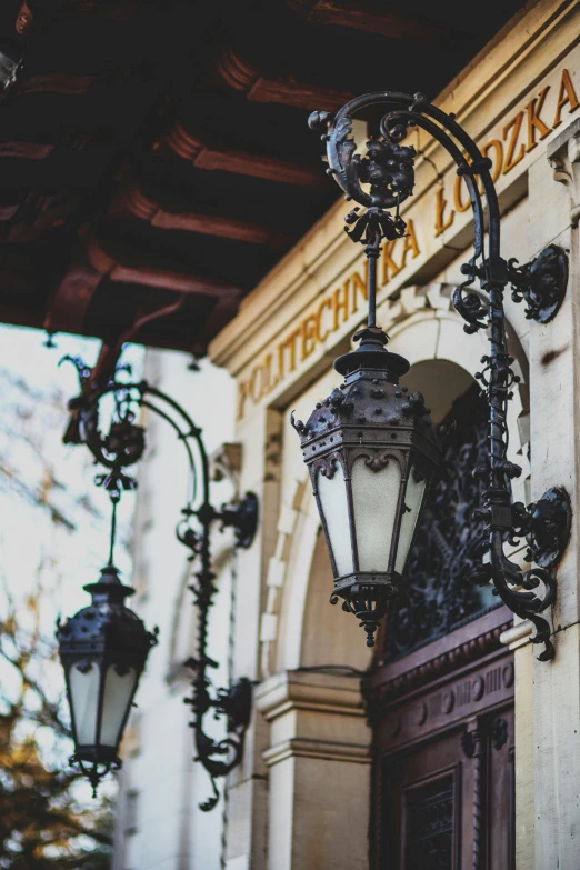 an ornate light post hangs over the door of a historical building