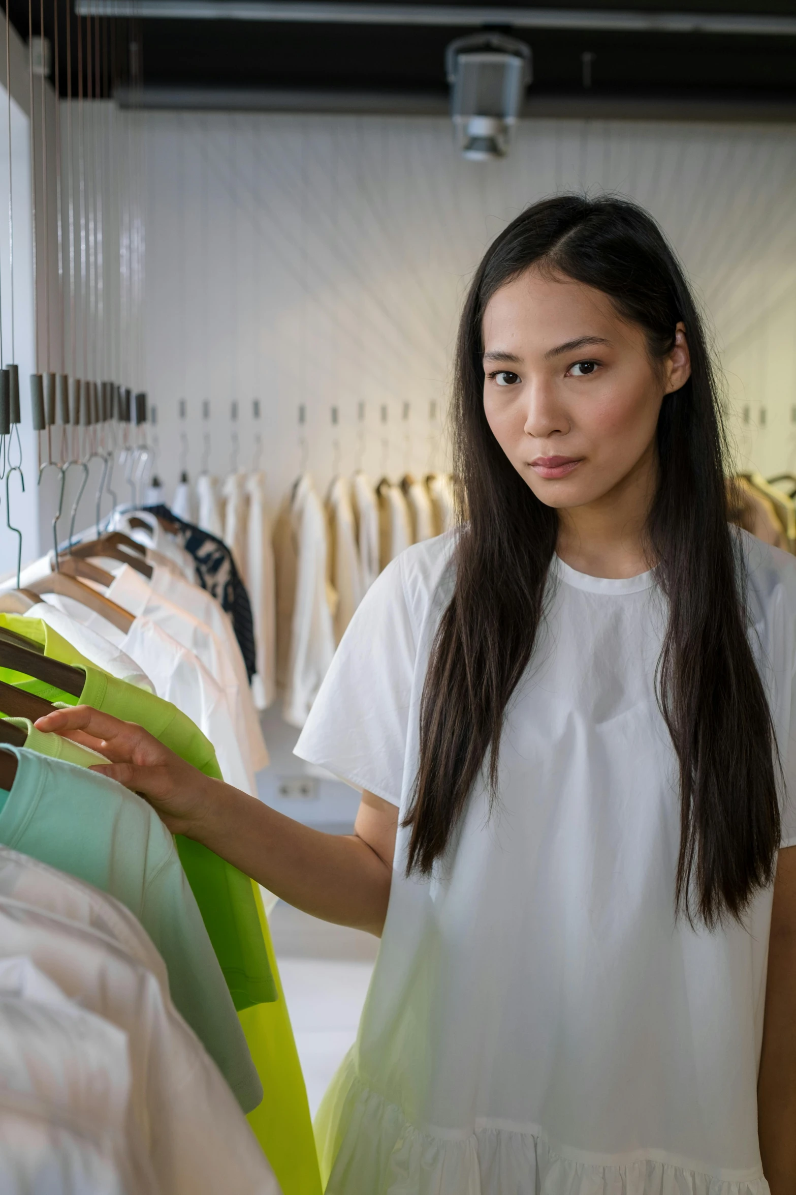 a woman that is standing in front of some clothes