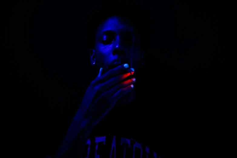 a dark po of a woman smoking a cigarette in the dark