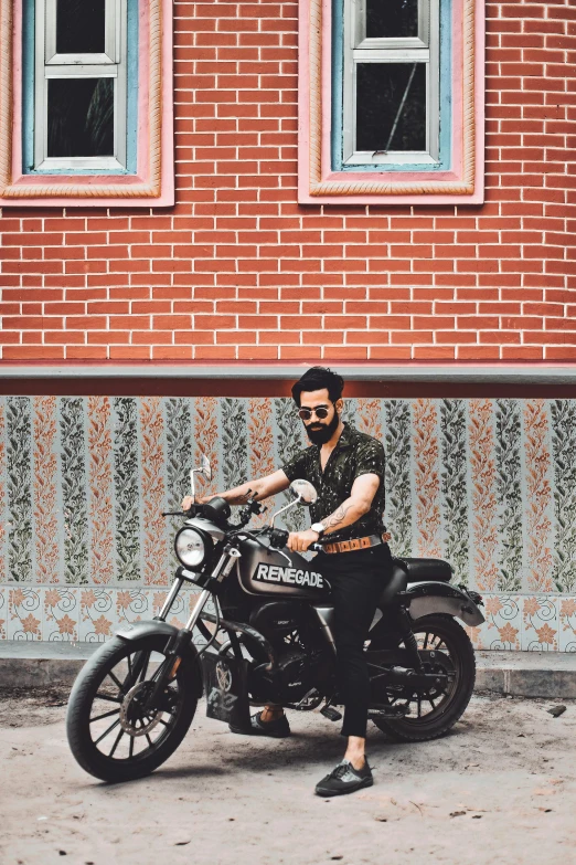 man in sunglasses and hat sitting on a motorcycle