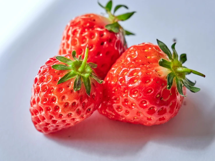 two red strawberries sit together on the table