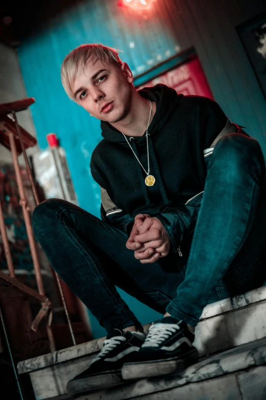 young man seated and looking pensive in a dark room