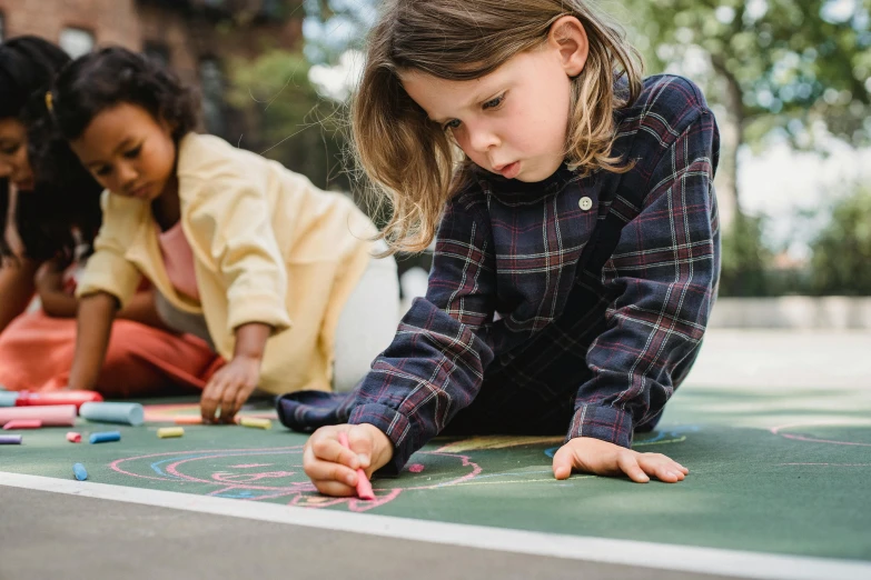 young children drawing on a chalk board at an outdoor event
