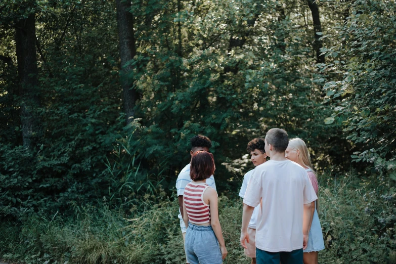 three people walking on a path in the woods