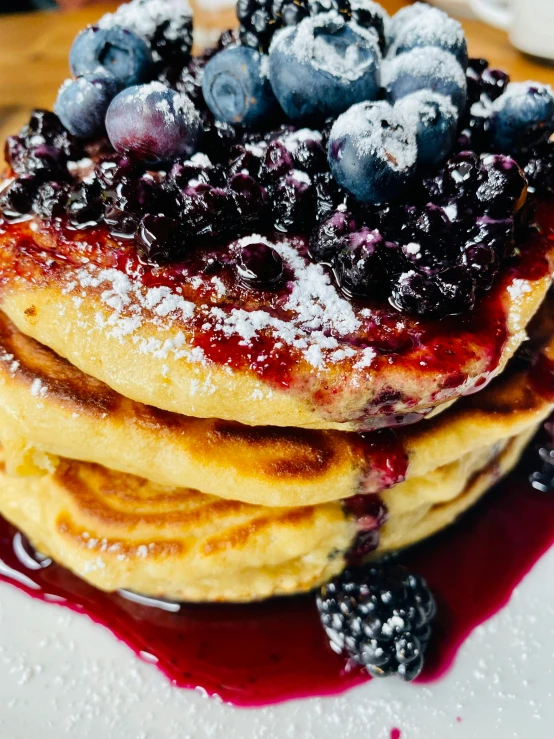 a pile of pancakes topped with blueberries on a plate