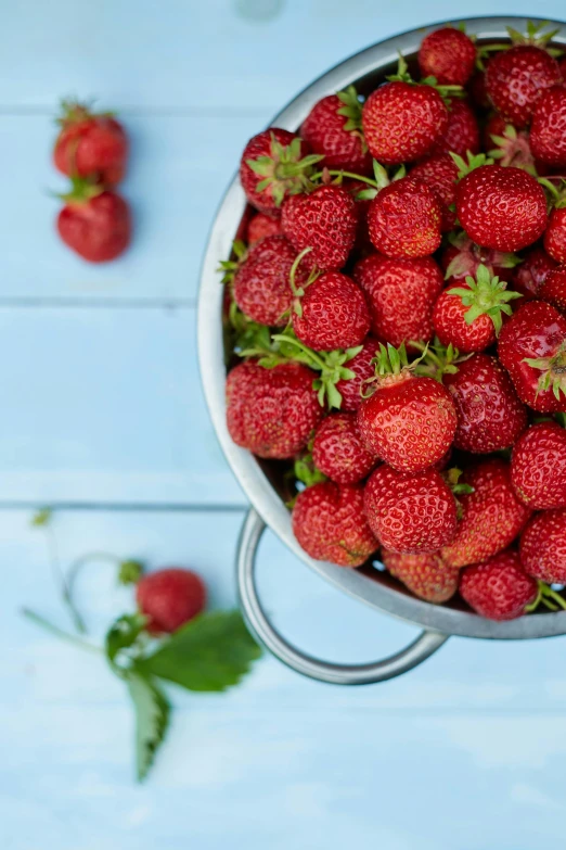 a bowl filled with a lot of ripe strawberries