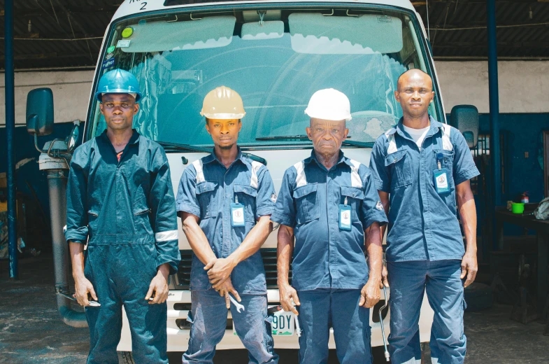 four construction workers standing in front of a truck