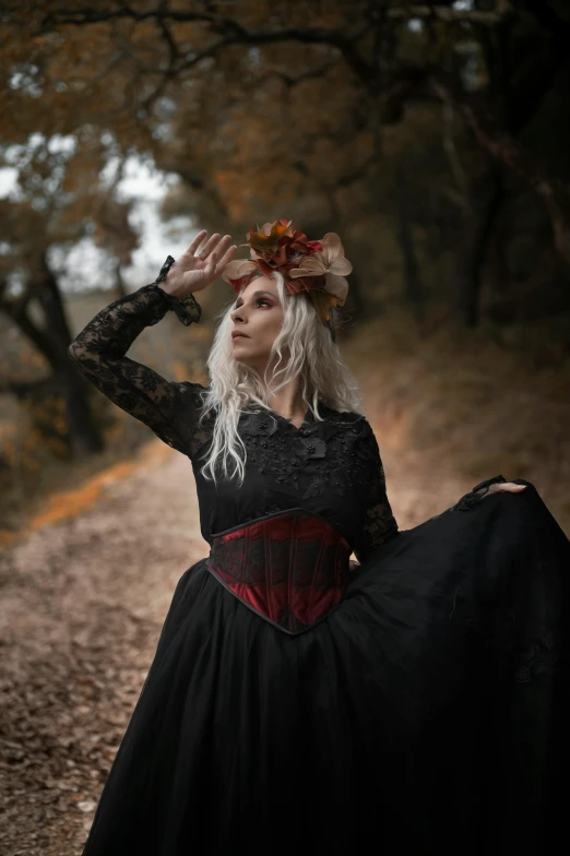 a woman dressed in victorian era clothing standing on a path