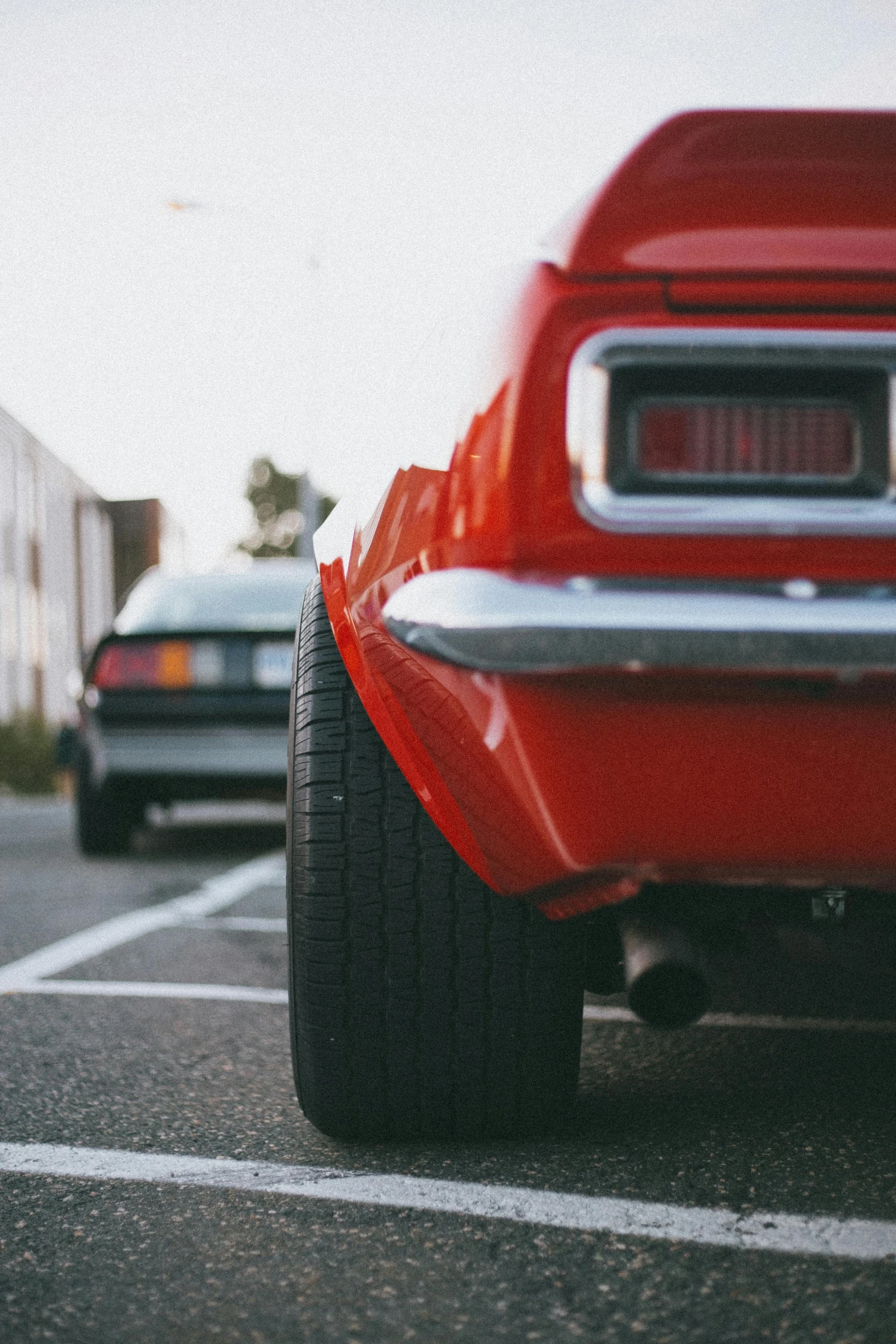 an old fashioned looking red car with large tires parked in a lot