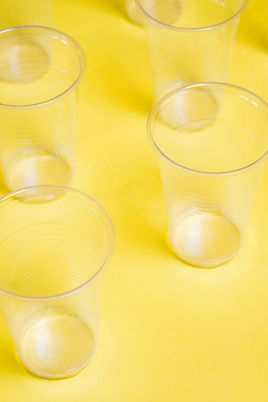 four clear plastic cups are lined up