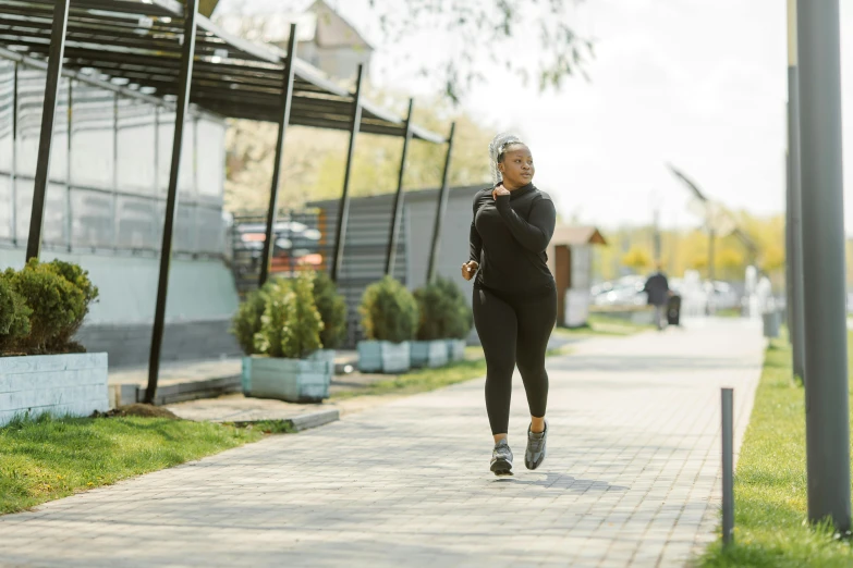 the woman runs down the sidewalk on her cellphone