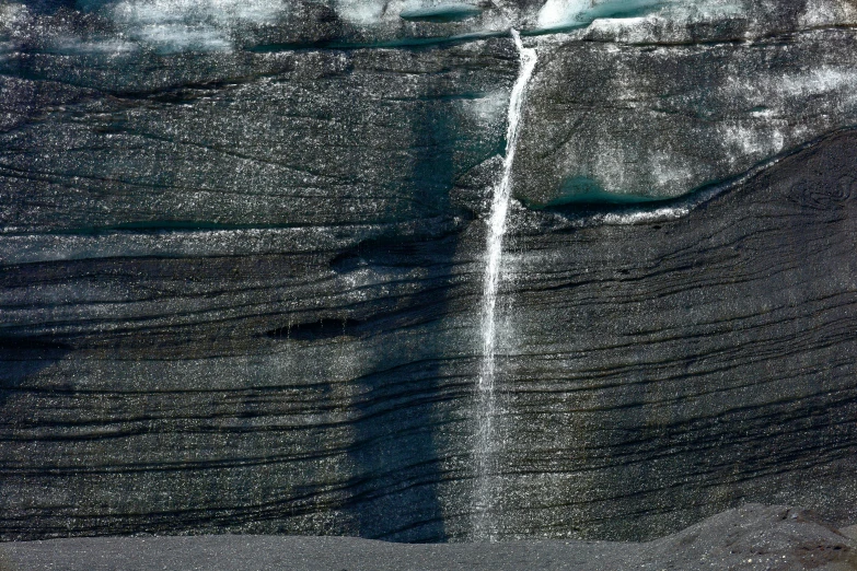 an iceberg is spouts water from the top of the mountain