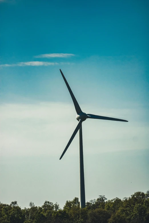 the windmill is against the blue sky and clouds